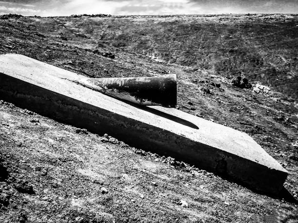 istock Cast iron wastewater outlet pipe daylighting from the treatment lagoon earthen berm 1409729977