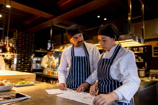 istock Team of cooks working at a restaurant and discussing the menu 1409729990