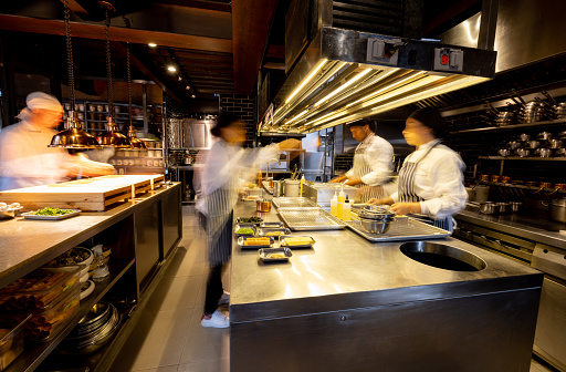 Cocineros agitados trabajando en una concurrida cocina comercial en un restaurante photo