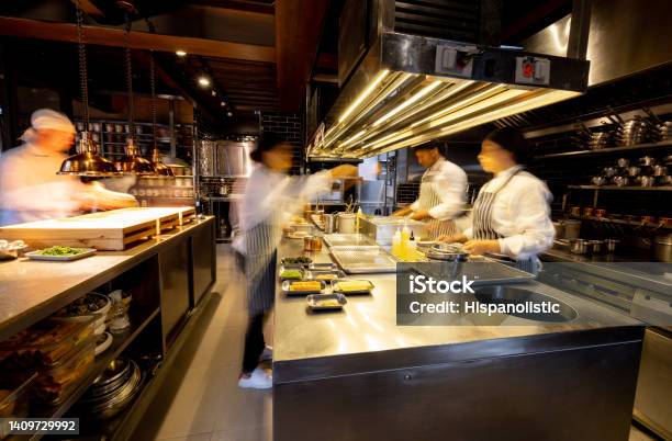 Hectic Cooks Working In A Busy Commercial Kitchen At A Restaurant Stock Photo - Download Image Now