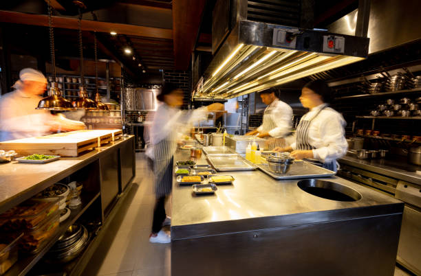 hectic cooks working in a busy commercial kitchen at a restaurant - storkök bildbanksfoton och bilder