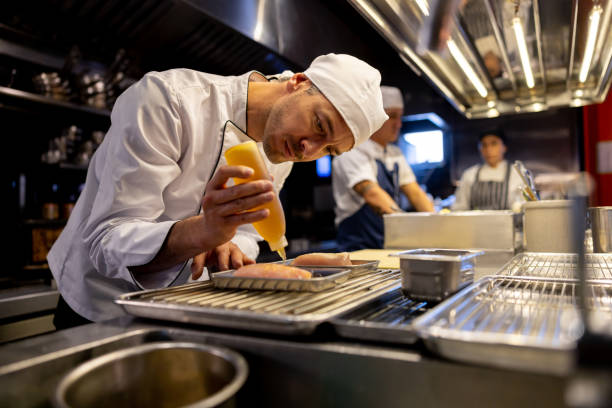chef preparando comida em um restaurante - serving food restaurant chicken - fotografias e filmes do acervo