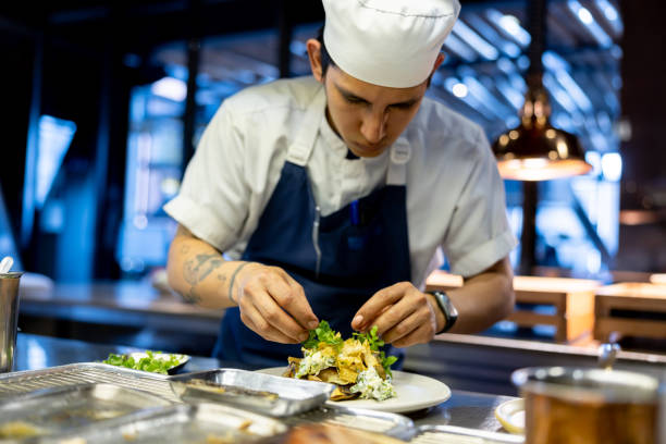 istock Cook working in the kitchen at a restaurant and preparing a plate 1409730027