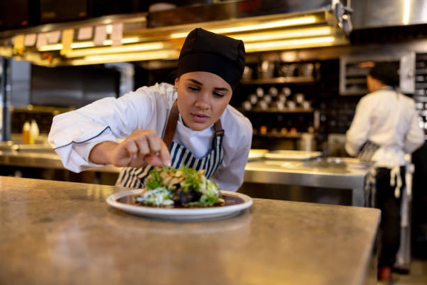 istock Female chef decorating a plate while working at a commercial kitchen 1409730040