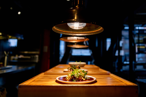 Delicious plate under a hot lamp at a restaurant waiting to be served - fine dining concepts