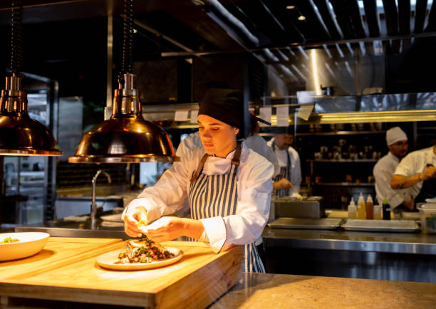 istock Female chef decorating a plate while working at a commercial kitchen 1409730572