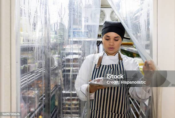 Chef Working At A Restaurant And Grabbing Some Ingredients From The Fridge Stock Photo - Download Image Now