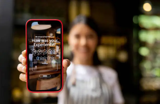 Photo of Waitress displaying an app to rate your experience at a restaurant