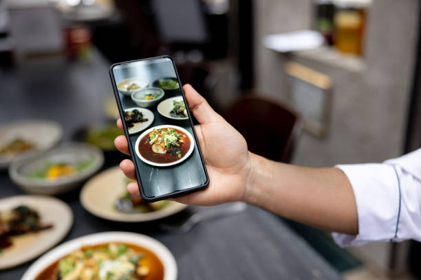 istock Chef taking a picture of a plate at a restaurant using a cell phone 1409730714