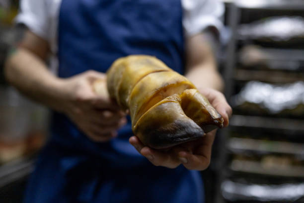 Close-up of a boiled or pork knuckle on a metal tray in the kitchen