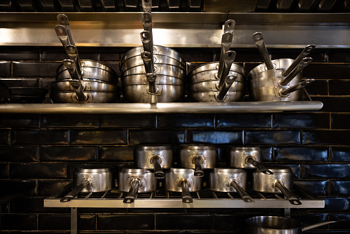 Pots and pans on the shelves at a commercial kitchen in a restaurant