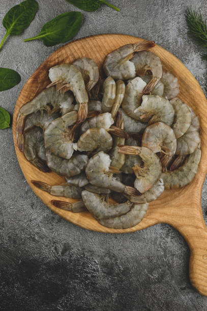 istock still life with raw fresh seafood on a wooden round plate board with spinach 1409730793