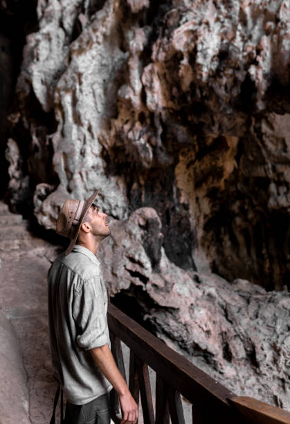 istock A young man wearing a hat is exploring a cave and having a look inside 1409737255
