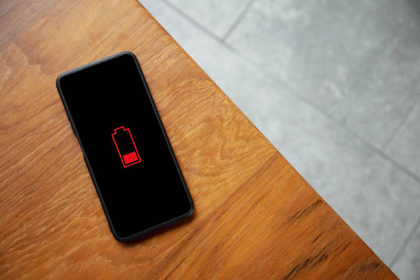 istock Looking down on a mobile phone without electricity on a wooden desktop 1409737643