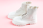 istock White demi-season martens boots made of eco-leather with a rough sole stand on a pink. 1409739071