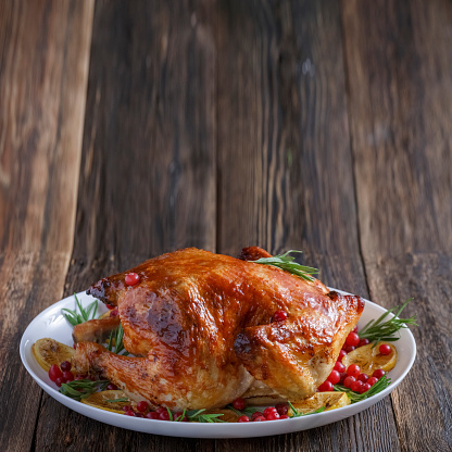 Grilled chicken on Christmas or Thanksgiving dinner table, close-up, conpy space for text