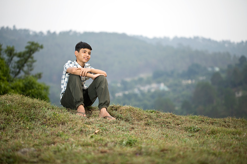 Teenage boy admiring nature outdoors from hill