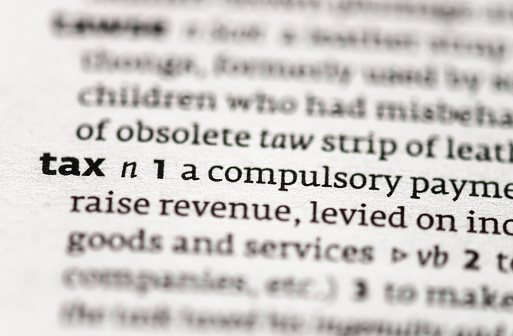 Macro image of a dictionary definition of the word 'tax'.