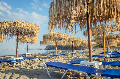 Beach loungers and umbrellas on a public beach in Greece on the island of Lemnos. Photo taken on Havouli Beach on Lemnos.