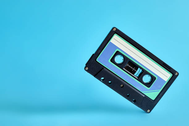 istock Pop music style attributes eighties, retro old school concept. Audio cassette levitates on a bright blue creative background. 1409742697