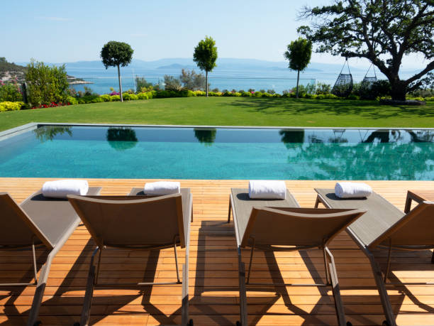 istock Deck chairs on Wooden plank floor against swimming pool 1409745562