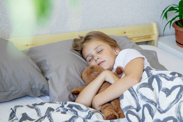 side view of a cute little blonde sleeping girl hugging her teddy bear in her cozy crib under a blanket in a dream. The concept of relaxation and sweet dreams side view of a cute little blonde sleeping girl hugging her teddy bear in her cozy crib under a blanket in a dream. The concept of relaxation and sweet dreams. 9 stock pictures, royalty-free photos & images