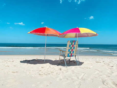 Empty beach with beach umbrellas and chair