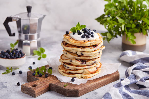 istock Stack of Pancakes with wild blueberries, served with sour cream and fresh berries 1409751876