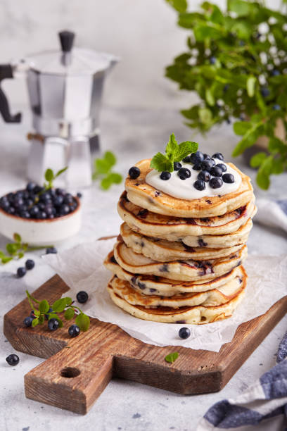 istock Stack of Pancakes with wild blueberries, served with sour cream and fresh berries 1409751877