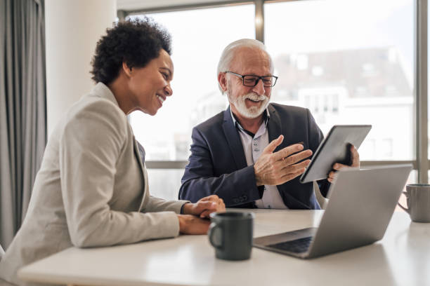 istock Senior businessman explaining strategy to female coworker. 1409752045