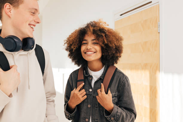 istock Two cheerful classmates standing together in corridor 1409752063
