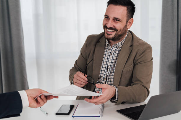 Smiling businessman preparing signing contract with client.
