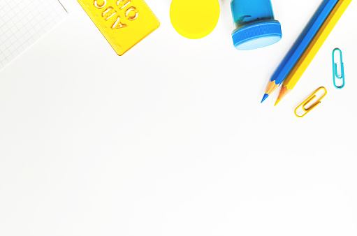 Yellow and blue stationery on white background top view. Design elements for cards, poster, banner. Back to school concept