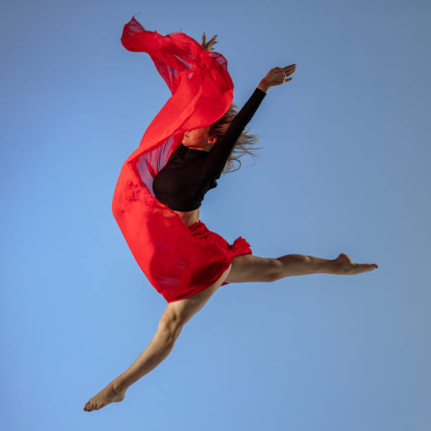 istock Dancer jump on blue background with red fabric 1409755792