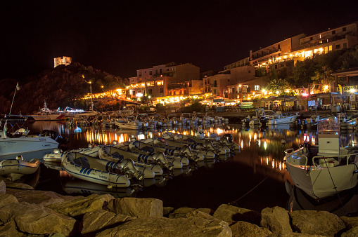 Porto Ota, France - 09 August 2012: Sunset and evening illuminated harbor in the city of Porto Ota on the island of Corsica in France.