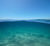 istock Blue sky with sand underwater sea over under water 1409760392