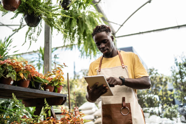 istock Young salesman working on a digital tablet at a garden center 1409761813