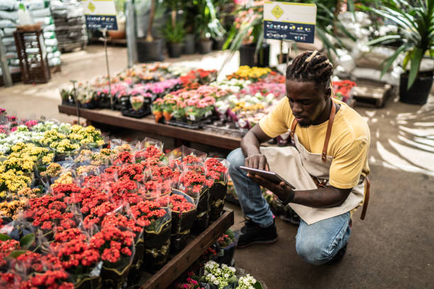 istock Young salesman working on a digital tablet at a garden center 1409762325