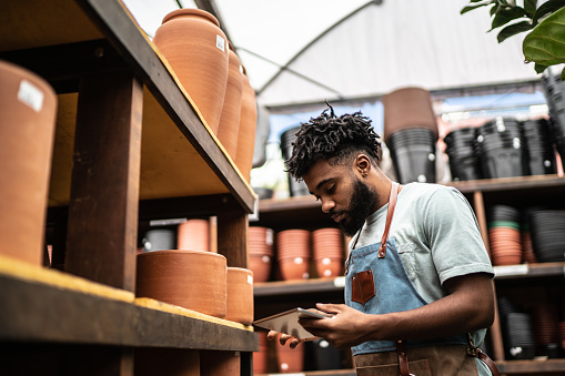 Young salesman working on a digital tablet at a garden center