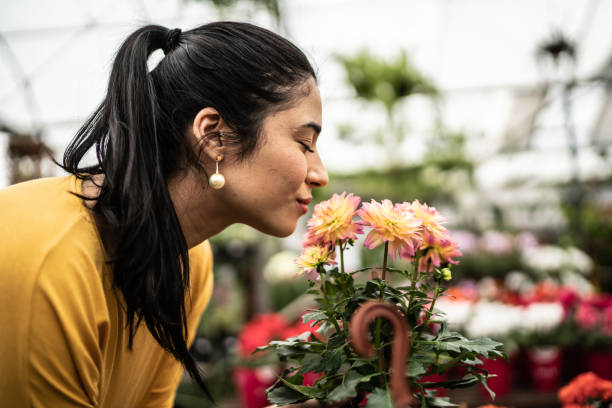 Young woman smelling flowers at a garden center