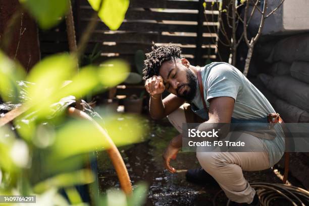 Tired Young Man Working At A Garden Center Stock Photo - Download Image Now - Gardening, Dizzy, Disappointment