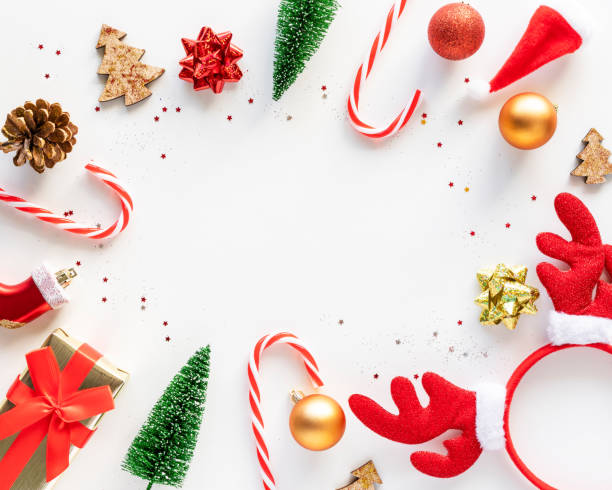 istock Christmas frame of holiday decorations on white background with copy space in the middle, top view. 1409766471