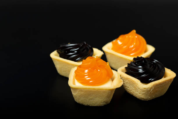 orange and black color pie on white plate, black background