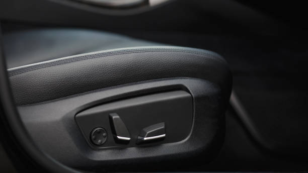 Car seat electronic switch button. lever for electronic seat adjustment in a modern premium car. Seat memory option. Close up of seat bottoms. stock photo