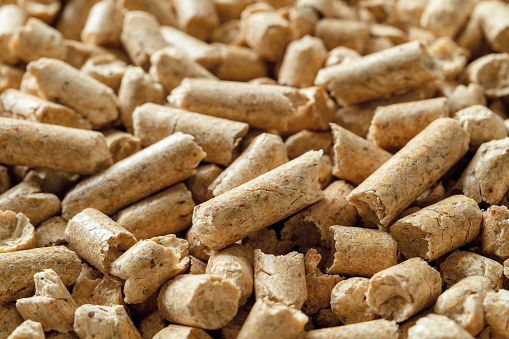Wooden pellets macro background. Texture of compressed sawdust granules. Alternative energy for home heating. Ecological biofuel made from compacted sawdust. Renewable energy concept. Front view.