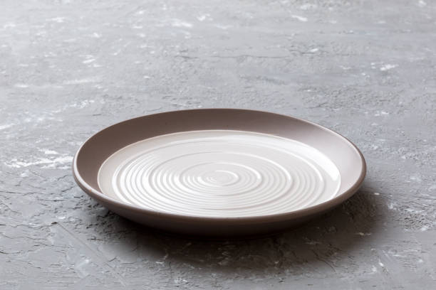 istock Perspective view of empty light plate on cement background. Empty space for your design 1409770155