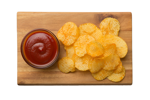 Delicious fried potato chip and ketchup, isolated on white background. Tasty round potato slice in closeup. Top view.