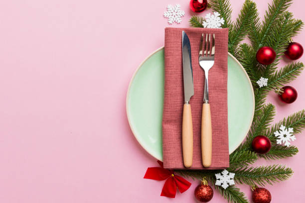 istock Christmas table place setting with christmas decor and plates, kine, fork and spoon. Christmas holiday background. Top view with copy space 1409770240