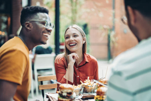 istock Happy friends in a side walk fast food restaurant 1409771633