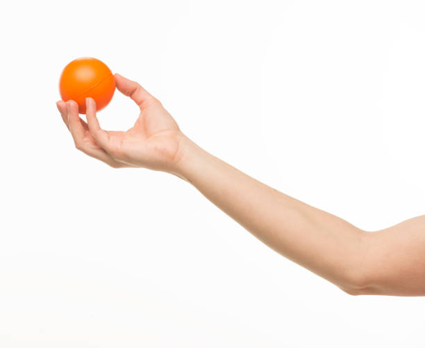 istock hand holding orange sponge ball isolated 1409775633